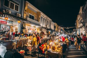 Shoppers and sellers in a a lively night market in Southeast Asia.